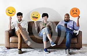 Diverse people sitting and holding emojis logos