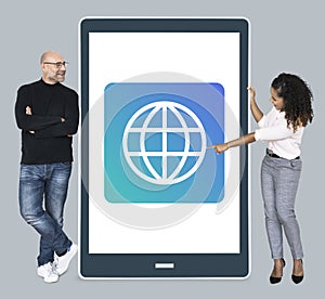 Diverse people standing beside a tablet with www icon