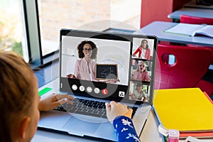 Diverse schoolchildren with female teacher having class during laptop video call