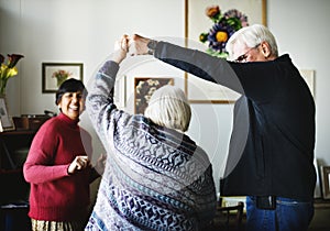 Diverse senior couple dancing at home