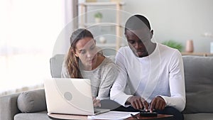 Diverse spouses manage family budget discuss loan agreement using computer