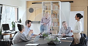 Diverse staff gather in boardroom share startup ideas discuss project