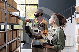 Diverse storehouse employees checking cardboard boxes