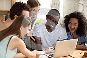 Diverse students watching comedy movie sitting at desk in room