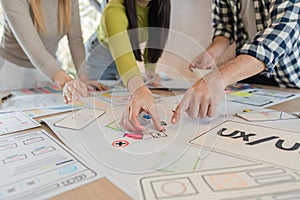 Diverse team analyzing UXUI design prototypes during collaborative session. photo