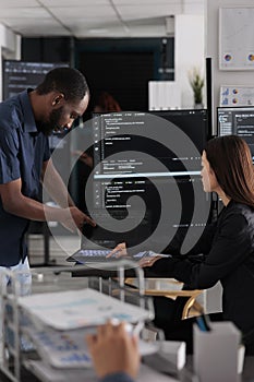 Diverse team of app developers talking about programming