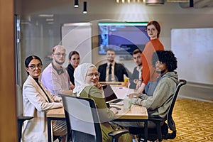 A diverse team of business experts in a modern glass office, attentively listening to a colleague's presentation