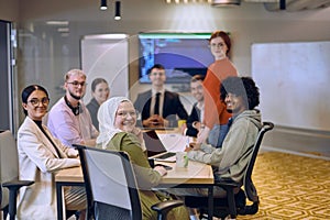 A diverse team of business experts in a modern glass office, attentively listening to a colleague's presentation