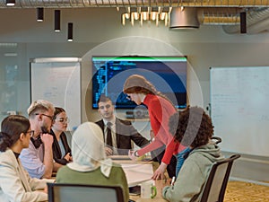 A diverse team of business experts in a modern glass office, attentively listening to a colleague's presentation