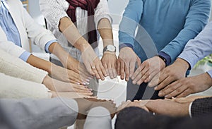 Diverse team of business people join their hands to show concept of teamwork, union, and support