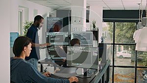 Diverse team of database developers analyzing code on terminal window
