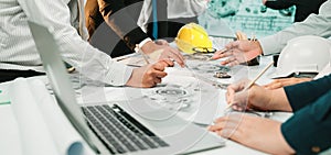 Collaborative Teamwork in Office Setting with Engineers and Architects Discussing Project Plans and Drafts on Table