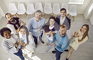 Diverse team of happy business people standing together, smiling and clapping hands