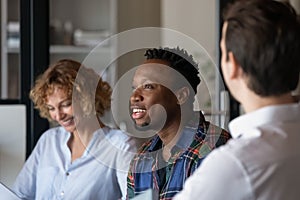 Diverse team of office employees discussing project together