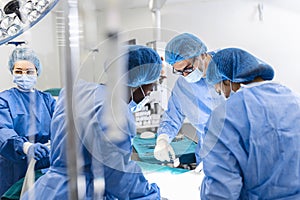Diverse Team of Professional surgeon, Assistants and Nurses Performing Invasive Surgery on a Patient in the Hospital Operating