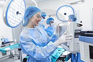 Diverse Team of Professional Surgeons Performing Invasive Surgery on a Patient in the Hospital Operating Room. Nurse Hands Out