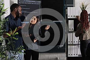 Diverse team of programmer analyzing html code on laptop