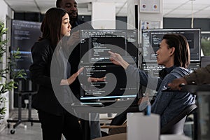 Diverse team of programmers coding html script information on computer at desk table