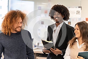 Diverse team smiling and sharing ideas at work.