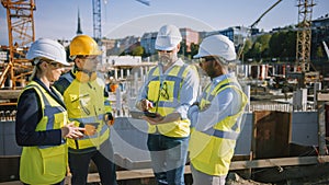 Diverse Team of Specialists Use Tablet Computer on Construction Site. Real Estate Building Project