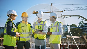 Diverse Team of Specialists Use Tablet Computer on Construction Site. Real Estate Building Project