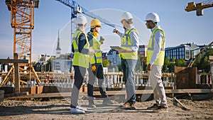 Diverse Team of Specialists Use Tablet Computer on Construction Site. Real Estate Building Project