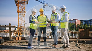 Diverse Team of Specialists Use Tablet Computer on Construction Site. Real Estate Building Project