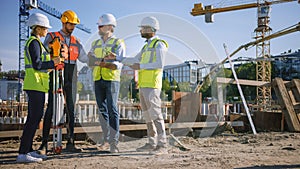 Diverse Team of Specialists Use Tablet Computer on Construction Site. Real Estate Building Project