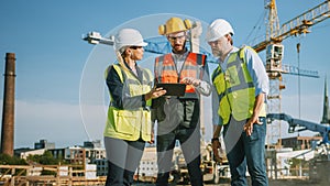 Diverse Team of Specialists Use Tablet Computer on Construction Site. Real Estate Building Project