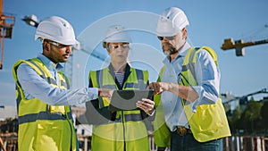 Diverse Team of Specialists Use Tablet Computer on Construction Site. Real Estate Building Project