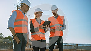 Diverse Team of Specialists Use Tablet Computer on Construction Site. Real Estate Building Project