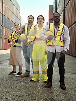 Diverse team of workers standing in front of containers