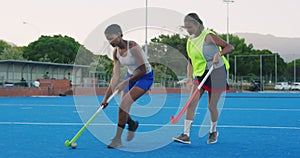 Diverse team of young field hockey players playing on astroturf in a game. Young girls practicing at school. Full length