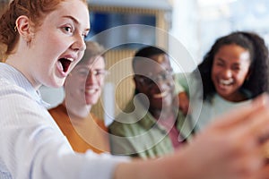 Diverse teenagers taking selfies together