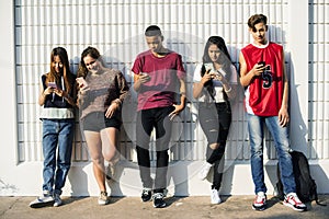 Diverse teenagers with their mobile phones photo