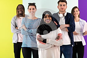 Diverse teenagers using mobile devices while posing for a studio photo in front of a colorful background