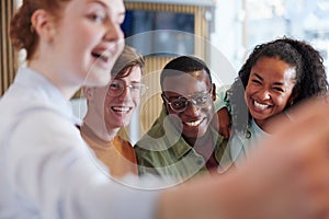 Diverse teens taking selfies together