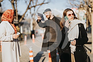 Diverse urban people on sunny street with smart phone and coffee