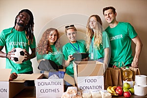 Diverse volunteers packing, collecting humanitarian aid in donation box