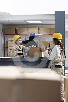 Diverse warehouse team using bar code scanners to manage packages