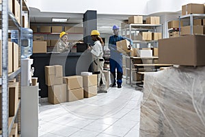 Diverse warehouse team using bar code scanners to manage packages