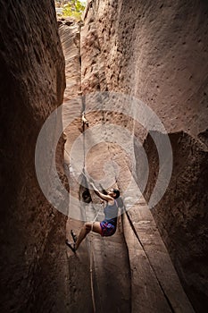 Diverse woman rock climbing in a beautiful slot canyon near Zion National Park