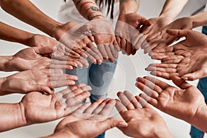 Diverse women holding their hands open palm together, making a circle over grey background. Concept of support, racial