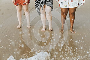 Diverse women soaking their feet in the water