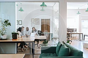 Diverse work colleagues meeting together in an office