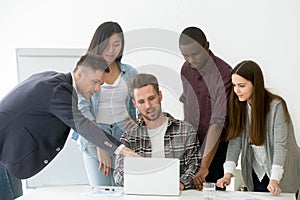 Diverse work team working together at laptop during meeting