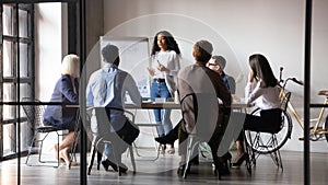 Diverse workers listening african businesswoman tell about strategy at meeting