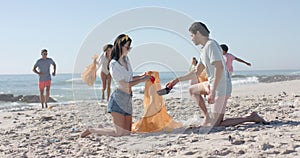 Diverse young adults participate in a beach cleanup, collecting trash