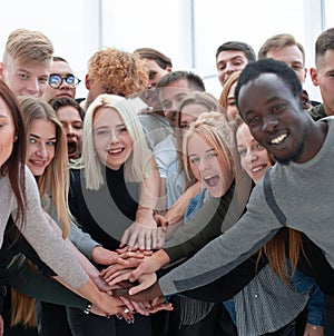 Diverse young people putting their hands together