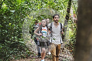 Diverse young people trekking in a tropical forest